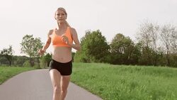 SLO MO TS Female marathon runner running on asphalt road Stock Footage