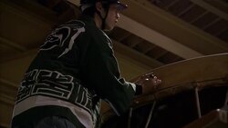 A drum maker measures and makes notations on the edge of a huge taiko drum. Stock Footage