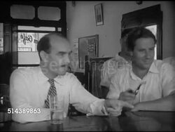 1953: KUALA LUMPUR, MALAYA: Angled WS Rubber plantation manager Tony Hooper w/ pipe walking into Coliseum Cafe & Hotel, sitting next to Civil Servant Robert Lindsey at bar, Angled WS BEHIND Armed rubber plantation managers wearing guns in holsters. Instructional Video