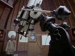 Low angle wide shot tilt down roof retracting as girl enters observatory / girl looking through telescope Stock Footage