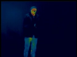 Thermographic image, cold man walks into frame from left, blows on hands to warm them, removes jacket, identical shots with info bar on DB 302 Stock Footage