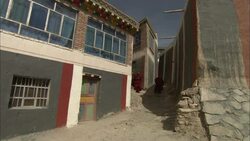 Tibetan monks walk in and out of a monastery. Stock Footage