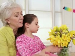 Girl and grandmother with daffodils and easter card Stock Footage
