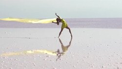 Young ballerina dancing on the salt lake with color tulle Stock Footage