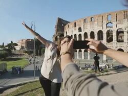 Tourist couple taking a photograph in front of the Coliseum Stock Footage