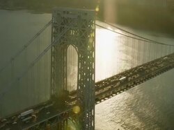 Aerial flying over George Washington Bridge at sunset, lens flair Stock Footage