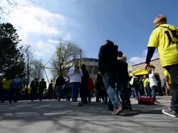 Low angle tilted mid shot of fans heading for the Stock Footage