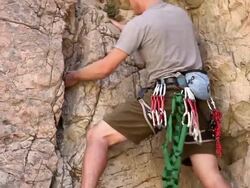 Tilt shot of of a blond male rock-climber. Stock Footage