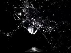 MS SLO MO Glass of water exploding and splashing against black background / Vieux Pont, Normandy, France  Stock Footage