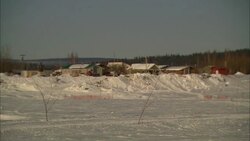 Houses border a wide, snowy field in Alaska. Stock Footage