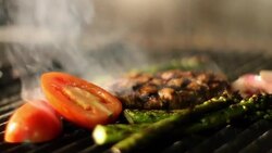 A steak and vegetables fry on a grill. Stock Footage