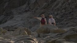 Archaeologists walk through rocky terrain in Egypt. Stock Footage