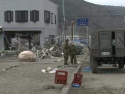 Destruction caused by tsunami after magnitude 9 Tohoku earthquake, north east Japan, March 2011. Japanese self defence forces positioned on street in tsunami hit Ishinomaki City,  Miyagi Prefecture Stock Footage