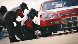 Pit-crew removes lug-nuts and jacks race-car Stock Footage