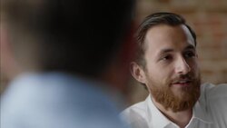 Bartender strokes beard and talks with business owner in staff meeting Stock Footage
