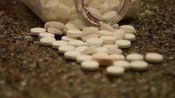 Bottle of Pills spilled all over the Counter white capsules with some random drugs mixed in Stock Footage