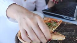 Woman using laptop and eating pizza Stock Footage