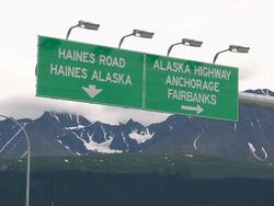 CU LA Shot of Overhead road signs at Haines Junction, showing Haines Highway & Alaksa Highway / Haines Junction, Yukon, Canada Stock Footage
