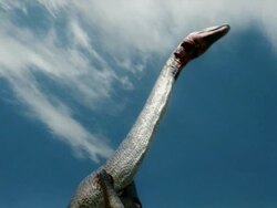 Low Angle hand-held - A Brachiosaurus struggles in the choke hold of another dinosaur in a computer-generated animation. / Washington, DC, USA Stock Footage