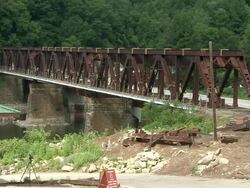 WS Demolition engineers in hardhats watching bridge over river surrounded by forested hills is destroying with explosives / Foxburg, Pennsylvania,USA Stock Footage