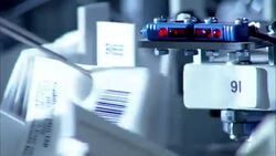 Extreme tight shot of individually packaged medications for hospital patients being dispersed via computer automation. Stock Footage
