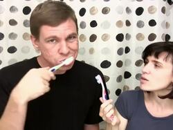 Couple brush teeth and talk Stock Footage