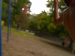 MS SLO MO PAN Shot of head and shoulders of Caucasian male child on park swing / Stanford, Connecticut, United States Stock Footage