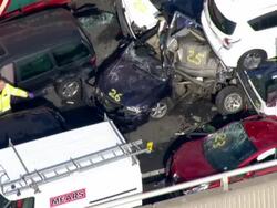Aerials firefighters looking at crushed cars News Clip