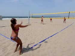 WS Establishing master shot of female beach volleyball players, showing the whole court, jump serving. Stock Footage