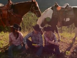 Cowboy/ cowgirls pause in mountain meadow Stock Footage