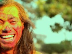 Portrait of a young man playing holi and laughing, Delhi, India Stock Footage