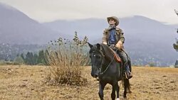 SLO MO Rancher riding his horse on in countryside Stock Footage