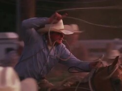 A cowboy with a lariat busts out the chute and attempts to rope a steer - shot in slow motion. Stock Footage