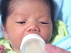 Baby infant suckling milk from bottle Stock Footage