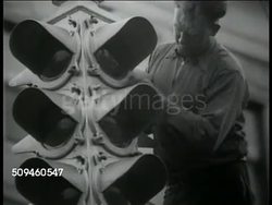 1938: TRAFFIC SIGNS: VS Male on ladder working on hanging taffic light. CU Road signs in book, visual aids. CU Road sign 'SLOW Dangerous Intersection' Male tightening bolts on 'Stop' sign. Instructional Video