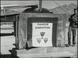A man places a metal screen inside a box marked radiation. News Clip
