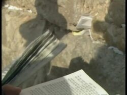 CU of prayer book with shadows of people praying on wall in background, Jerusalem Stock Footage