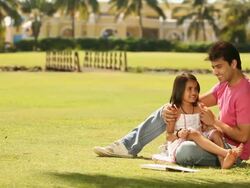 Man telling stories to his daughter in a park Stock Footage