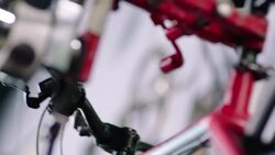 Bike mechanic adjusts brake lever cables and pedals on red bicycle Stock Footage