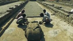 Young men in Bangladesh use simple wooden moulds to fashion bricks from a simple clay and water mix there actions are fast and rhythmical  Stock Footage