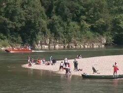 MS ZO People on sandbank near river edge / Kloster Weltenburg, Kehlheim, Bavaria, Germany Stock Footage