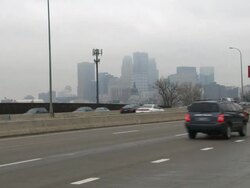 Morning traffic heading towards Minneapolis during rush hour with the city skyline in the background Stock Footage