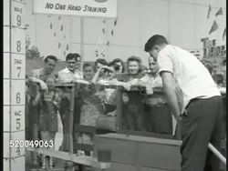 1946: PALISADES PARK: DRAMATIZATION: Man w/ glasses (Vita-Zone) holding stuffed Cupie Doll watching w/ others. PALISADES PARK: Strongman using mallet to measure strength, hitting to top bell. DRAMATIZATION: Man in glasses, others quickly looking up Instructional Video