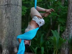 MS TS Woman runs and jumps up into fabric hanging from large tropical trees and performs aerial circus dance / Montezuma, Puntarenas, Costa Rica Stock Footage