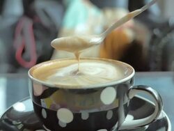 Slow Motion of coffee flowing from spoon into a cup Stock Footage