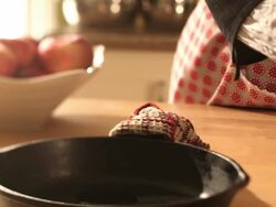 A woman pours oil in the pan in cast iron Stock Footage