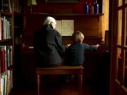 Slow push in on grandmother and grandson having fun playing the piano.  Stock Footage