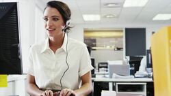 Businesswoman wearing headset using computer Stock Footage