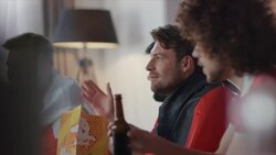 Sport fans sitting on couch watching tv and cheering Stock Footage