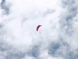 Low Angle hand-held - A parachutist glides across a cloudy sky / Great Barrier Reef, Australia Stock Footage